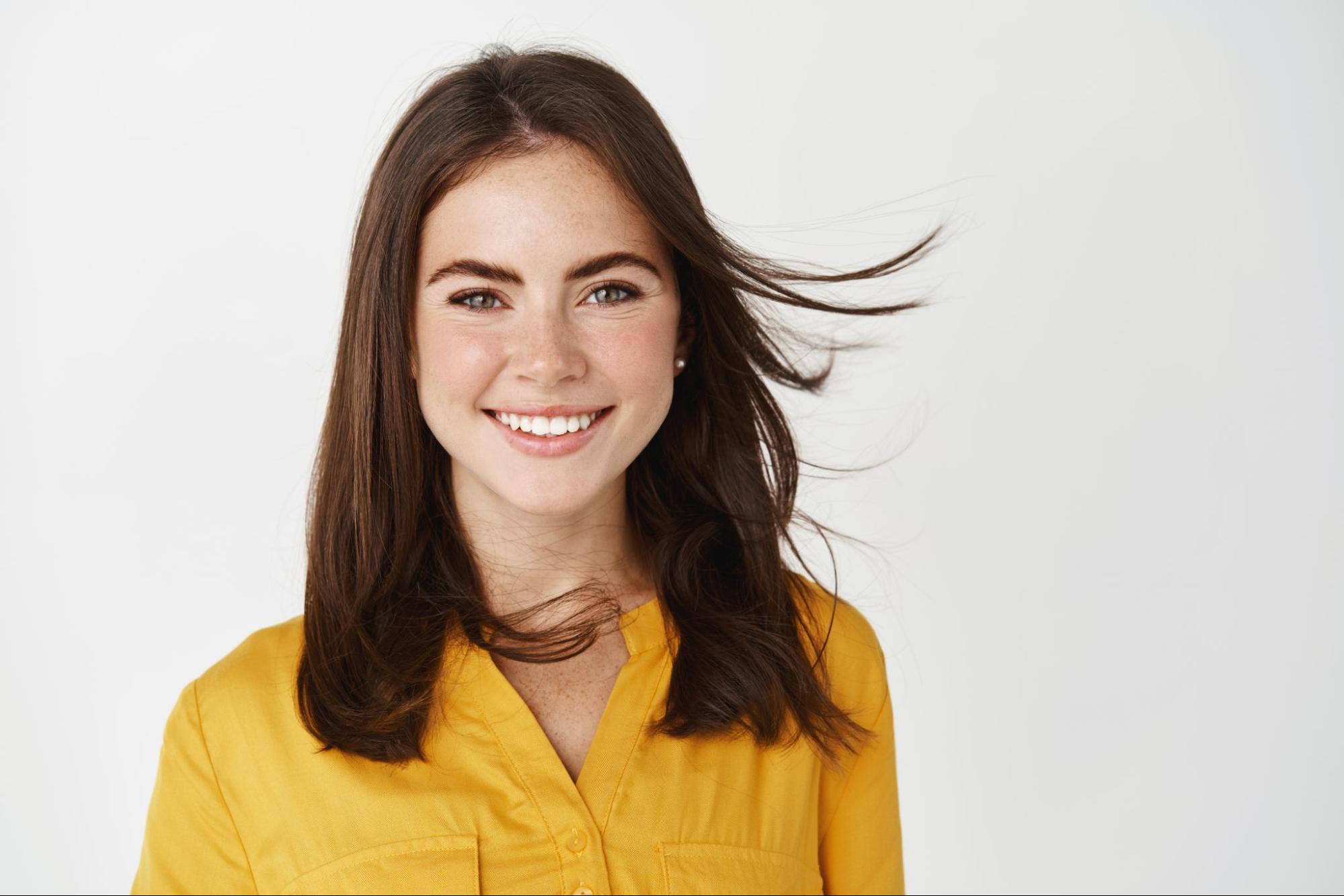 young attractive woman smiling, feeling healthy, hair flying on wind