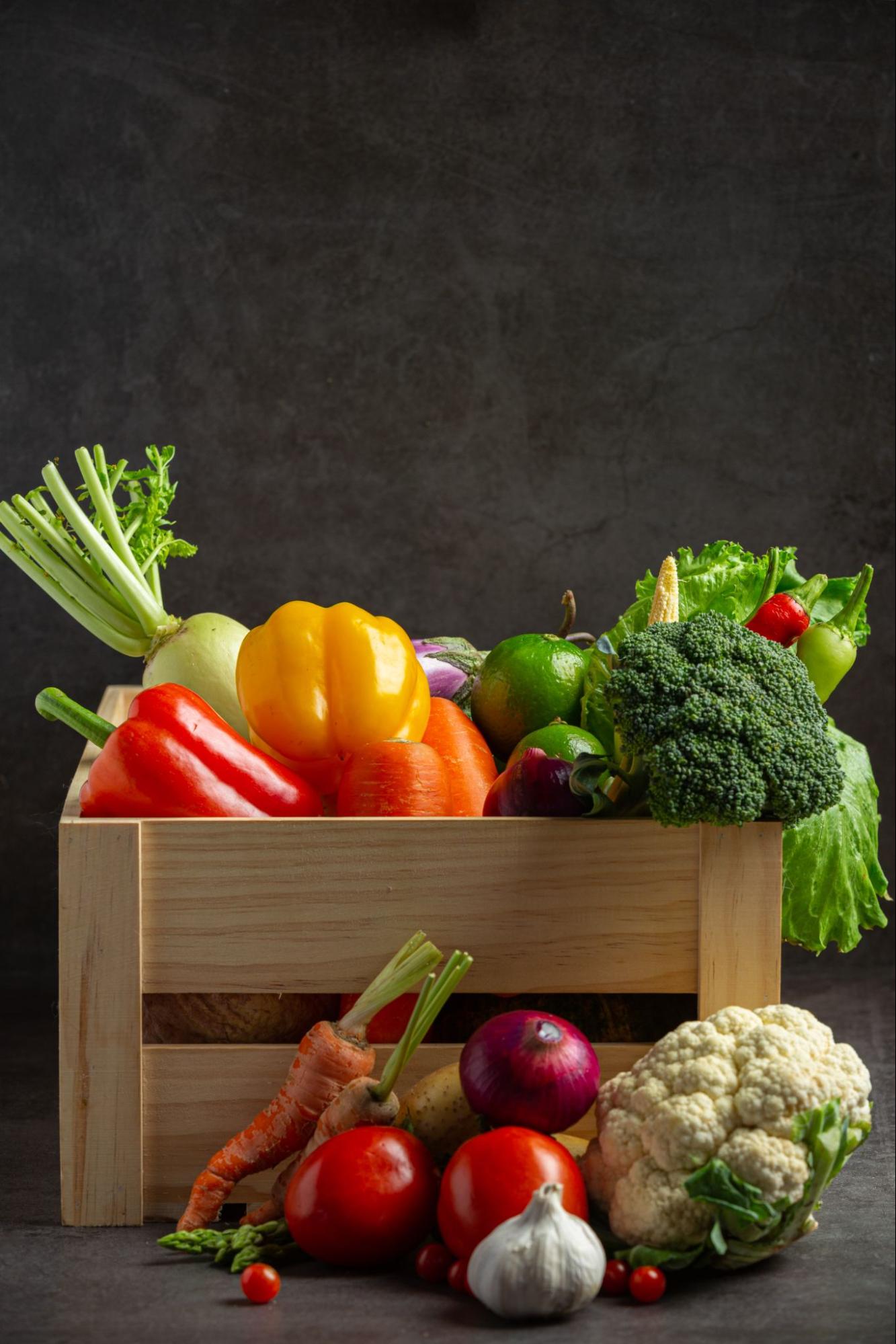 fruits and vegetables in a basket with black background