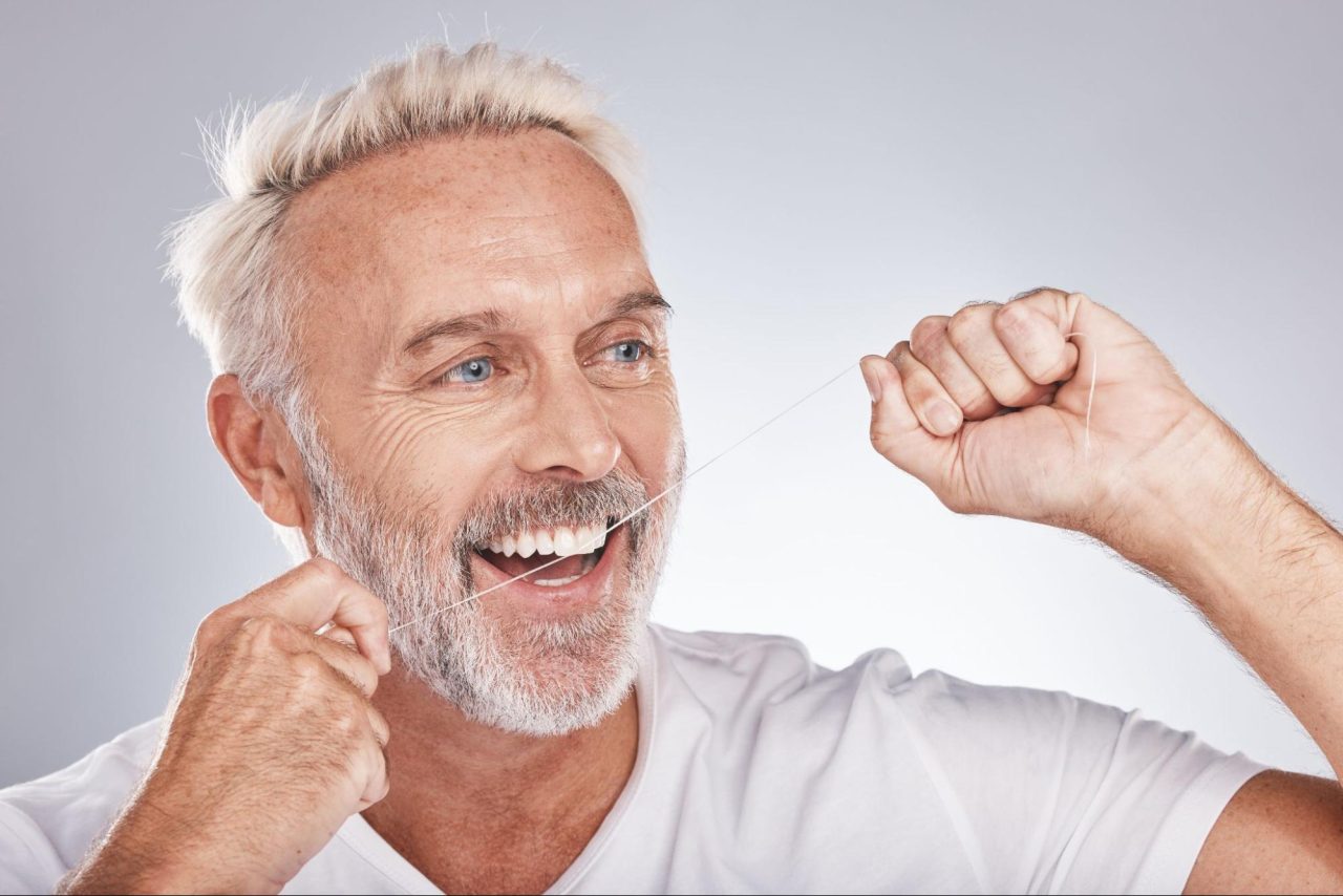 elderly man flossing